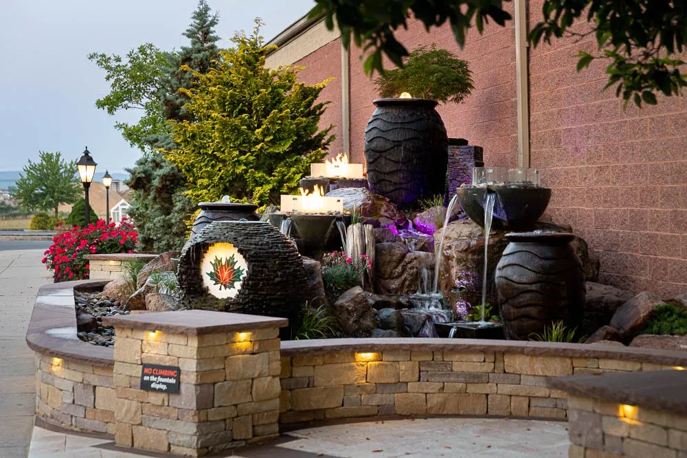 Stone fountain and planter wall with inset wall lights on
