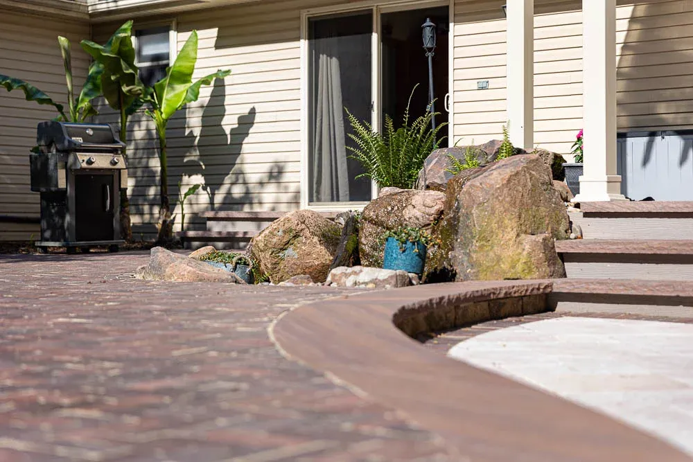 Stone-edged patio with planting and large rocks